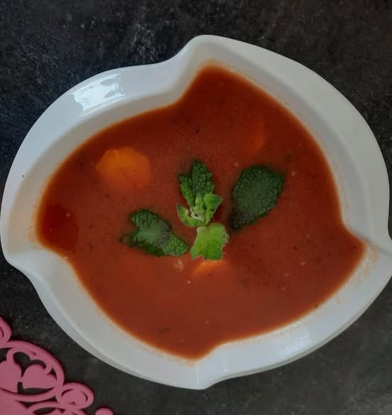 Zupa pomidorowa udekorowana zielonymi listkami